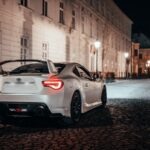 white porsche 911 parked beside road during daytime